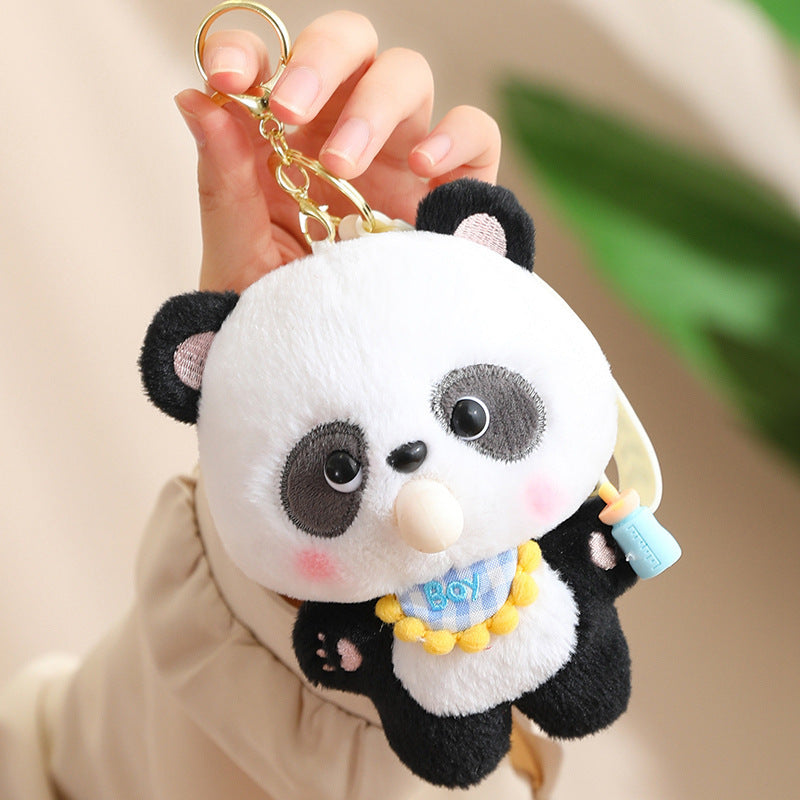 Plush panda keychain held by a hand against a neutral background