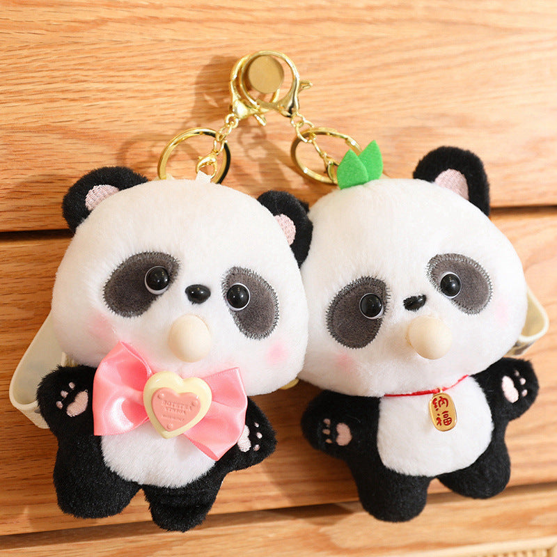 Two panda-shaped keychains on a wooden surface