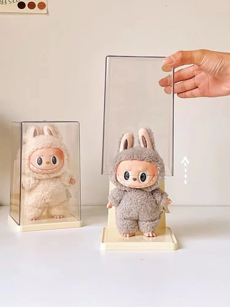 Plush toy in a bunny costume on a stand with a hand holding a transparent card.