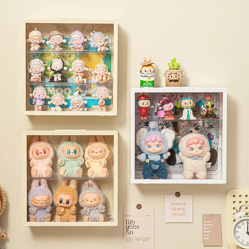 Collection of small figurines displayed in white shelves against a beige wall.