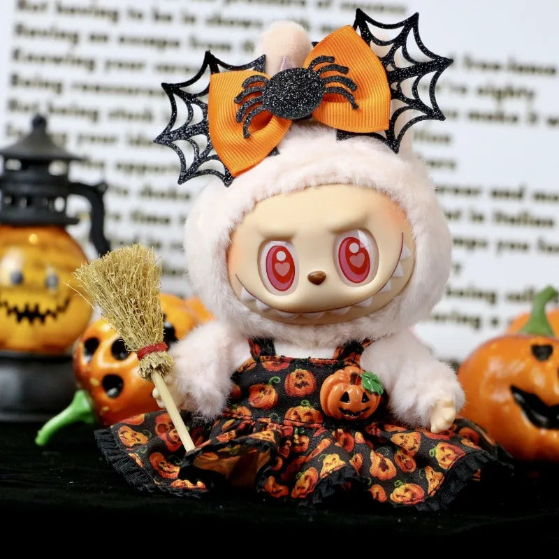 Halloween-themed plush toy with spider web bow, broom, and pumpkin patterned skirt.