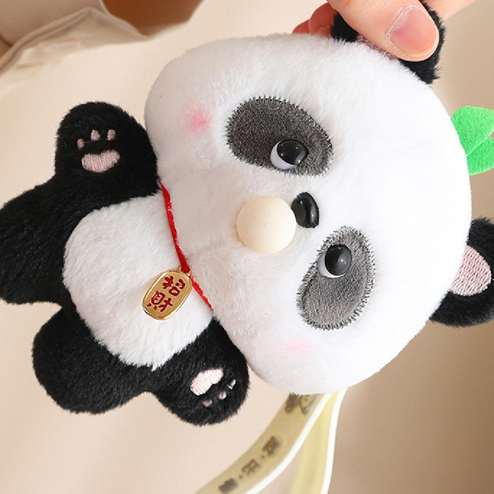 Plush panda toy held by a hand with a blurred background
