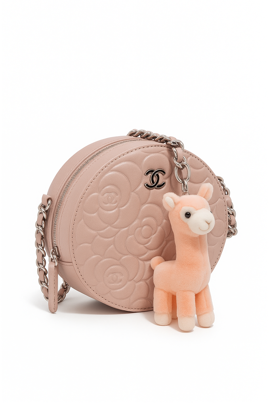 Pink quilted handbag with a small plush llama toy on a white background