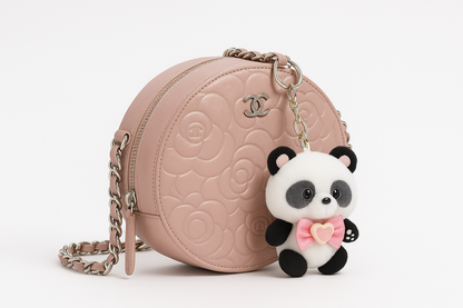 Pink Chanel bag with a panda charm on a white background