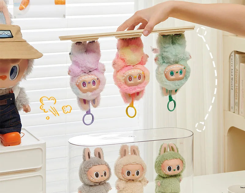 Plush toys hanging from a wooden stand with a blurred background