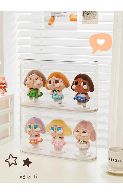 Set of small figurines in a clear display case on a white surface with a blurred background.