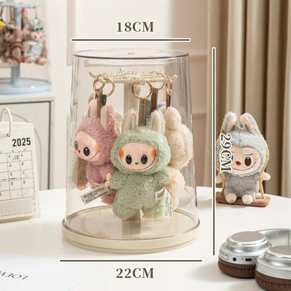 Plush keychains in a display case with measurements, calendar in the background
